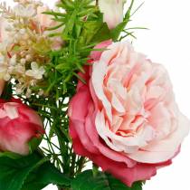 Bukett med kunstige roser i en haug med rosa bukett av silkeblomster